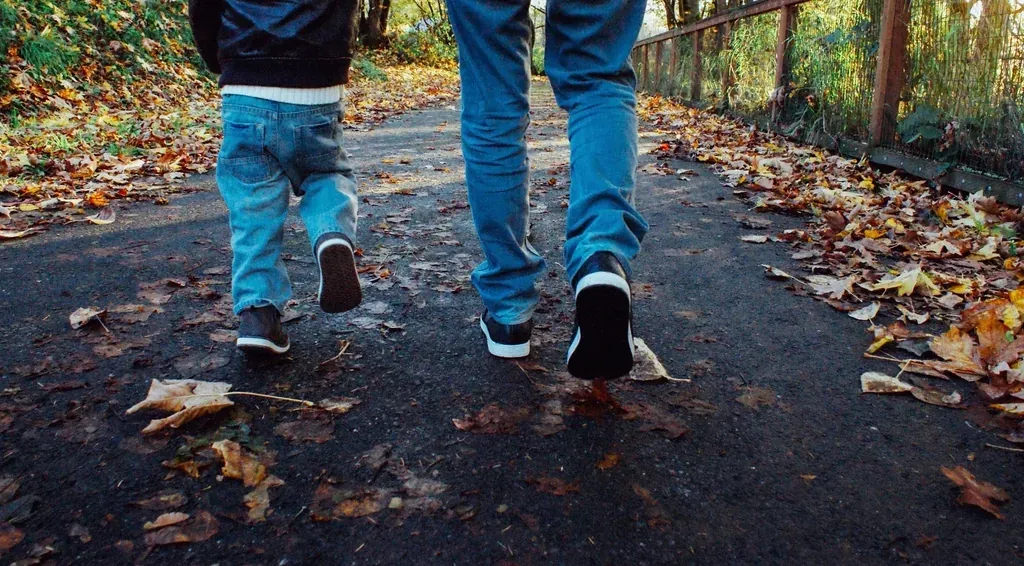 Zwei Menschen gehen auf einem Weg im Park spazieren